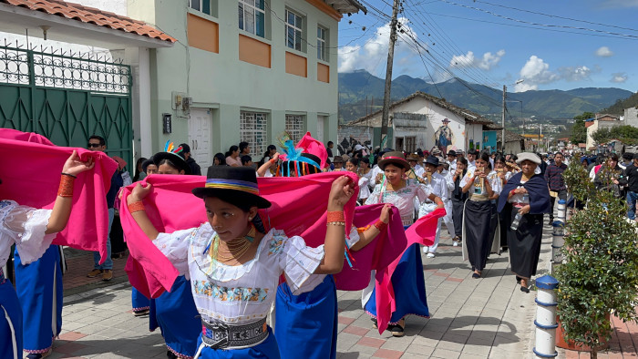 Young people in traditional Kichwa dress march, playing music and dancing, at the Pawkar festival in Ecuador.
