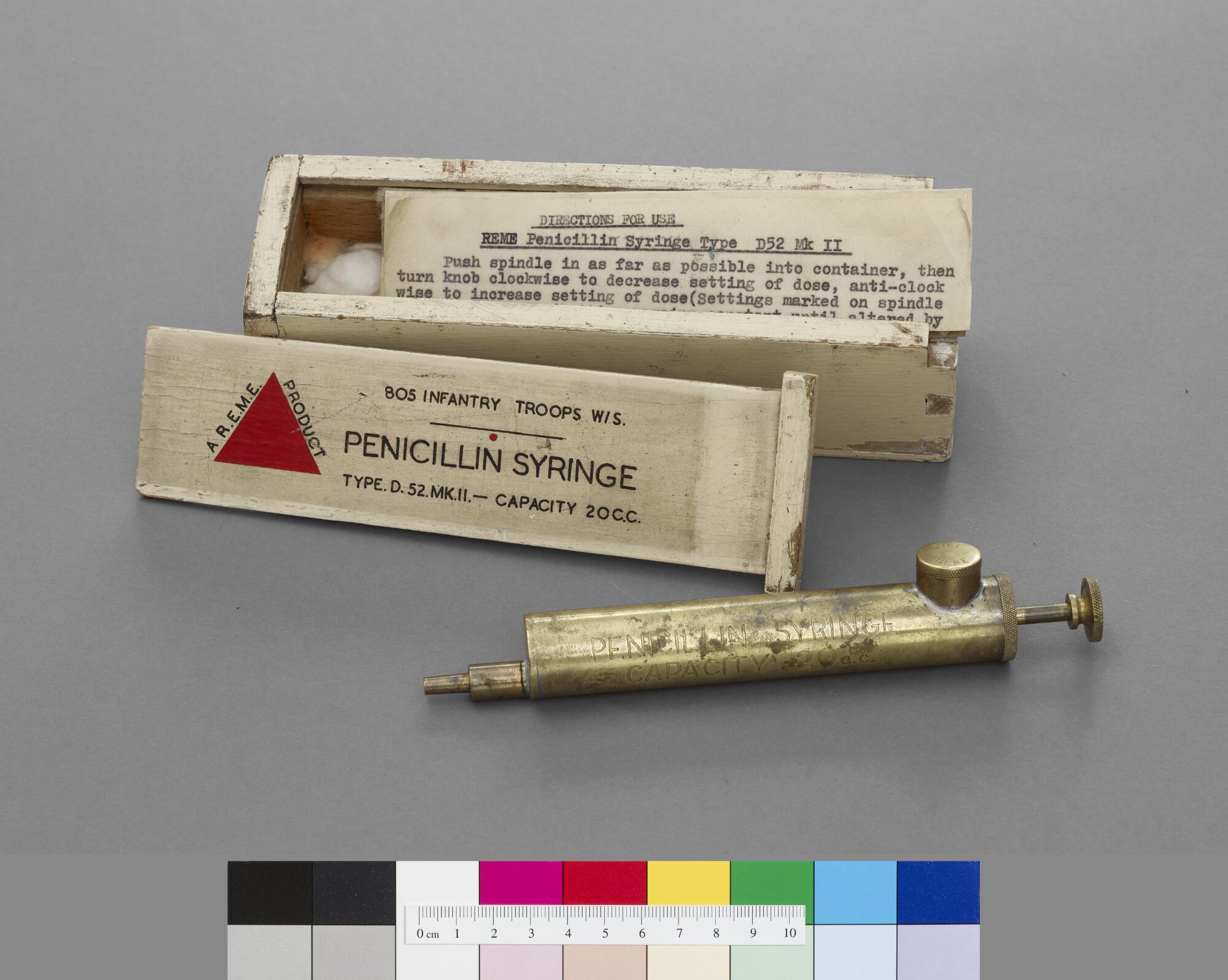 Medical metal syringe with wooden box and instructions.