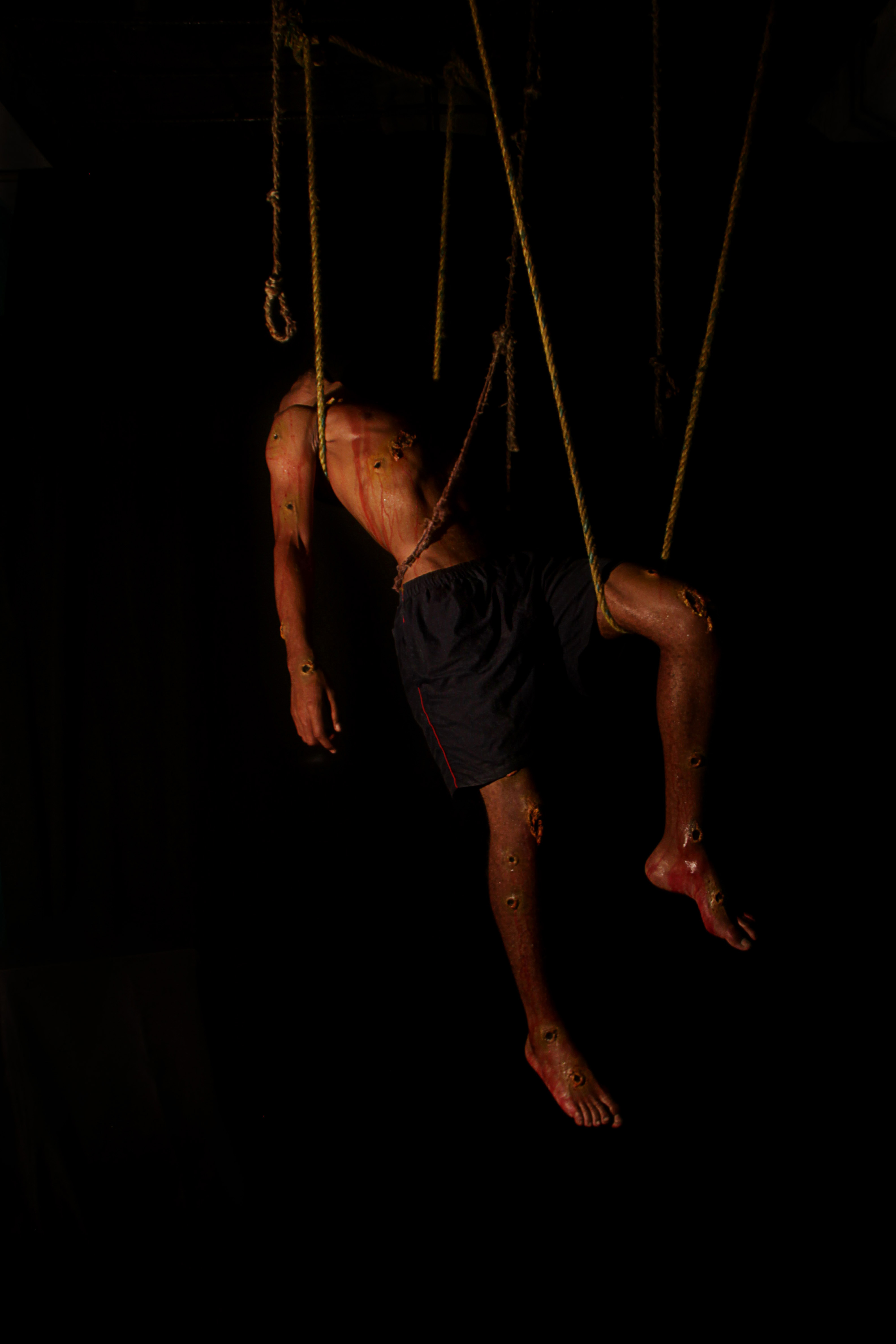 Photograph of a man suspended by a rope