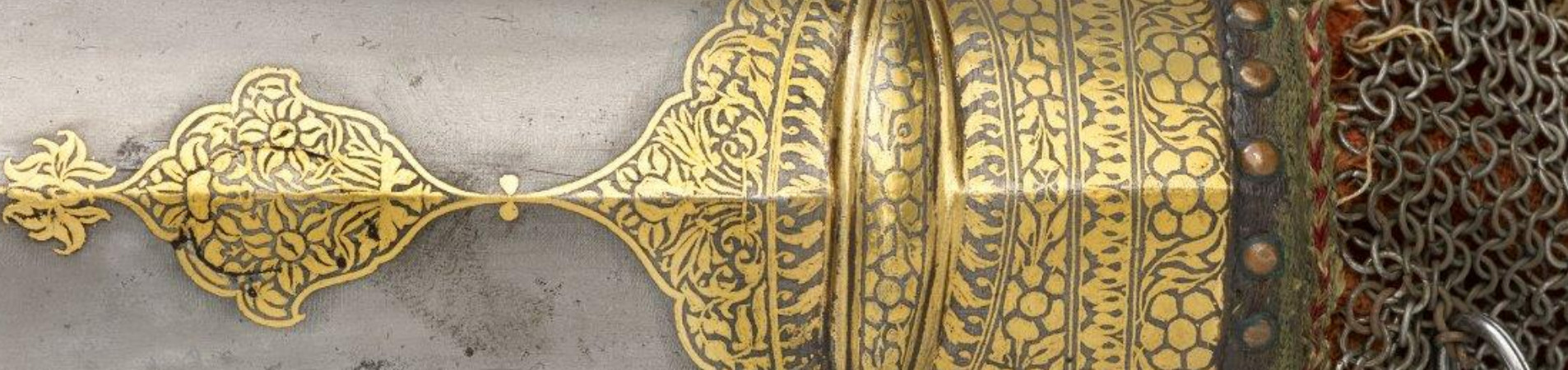 A steel gauntlet with gold decoration and textile lining.