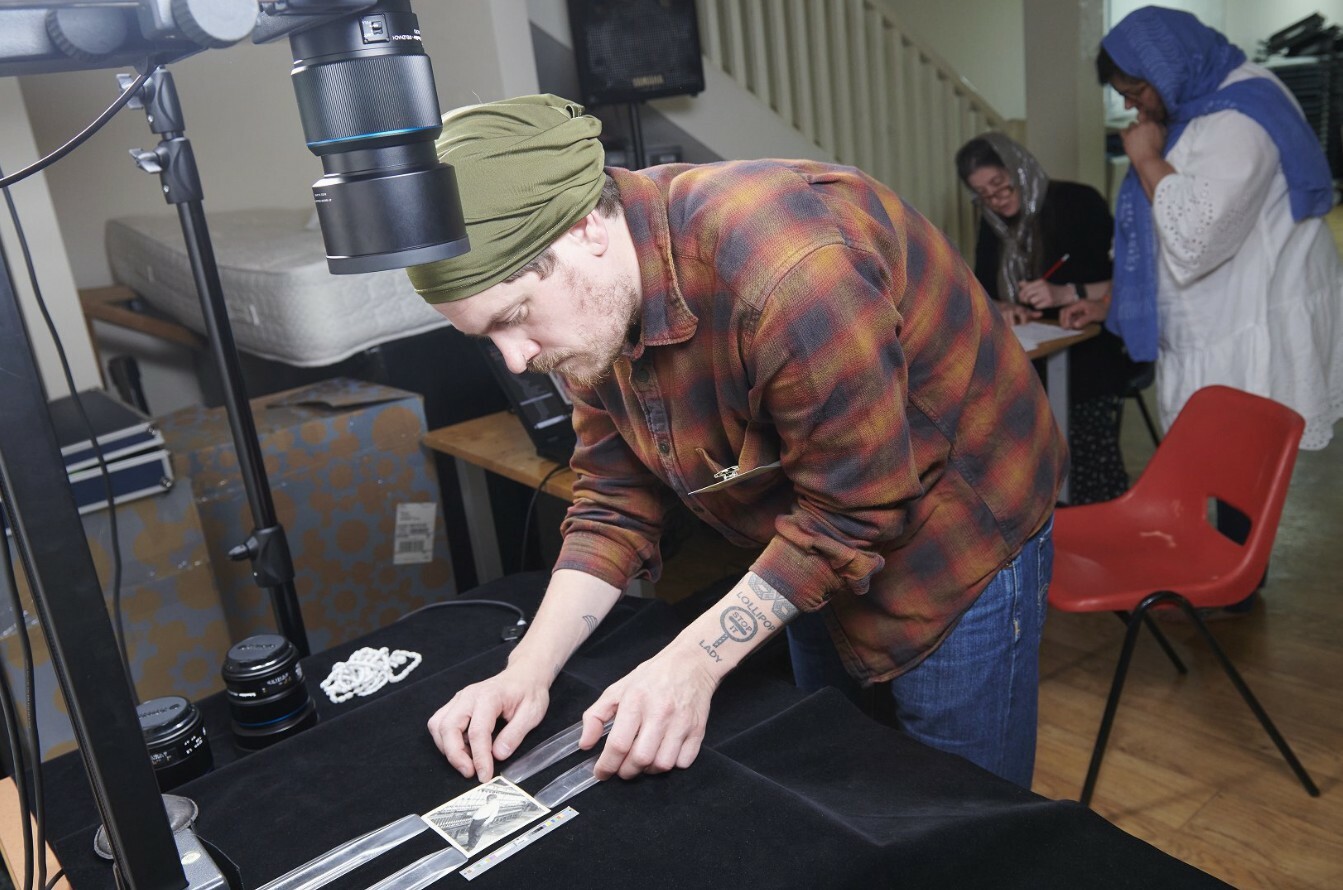 Photograph showing Jamie Robinson from the John Rylands Research Institute and Library, capturing material at a Sikh community digitisation day at a Gurdwara in Manchester.