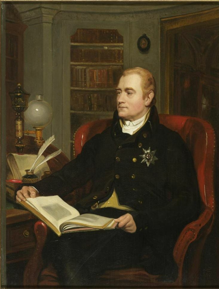 Earl Spencer seated reading a book.