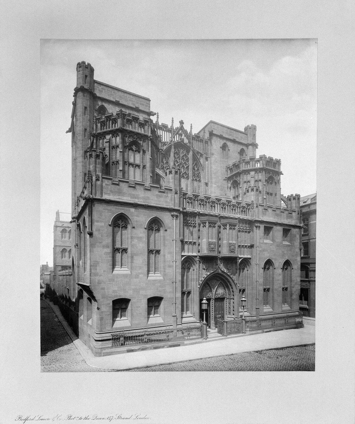 Black and white photograph of the John Rylands Library, showing its exterior and main entrance from Deansgate. 
