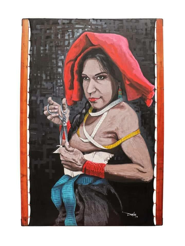 A figure holds scissors and fabric while wearing layered textiles and a red head covering against a dark backdrop.