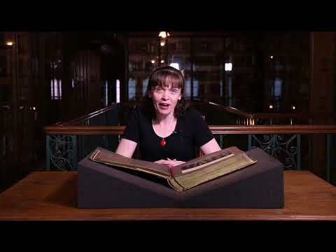 Video showing Fran Baker sat behind a table in the John Rylands Research Institute and Library, along with an open copy of the Manchester Guardian's Centenary Album.